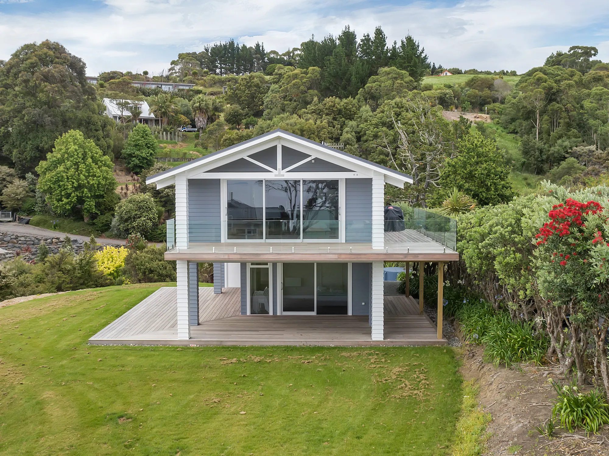 Two-storey weatherboard home on a bush-lined rural section
