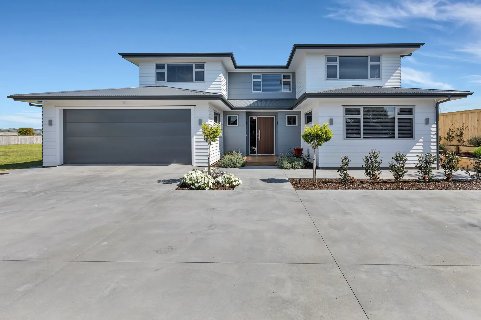 Two-storey weatherboard home with a double garage and wide driveway