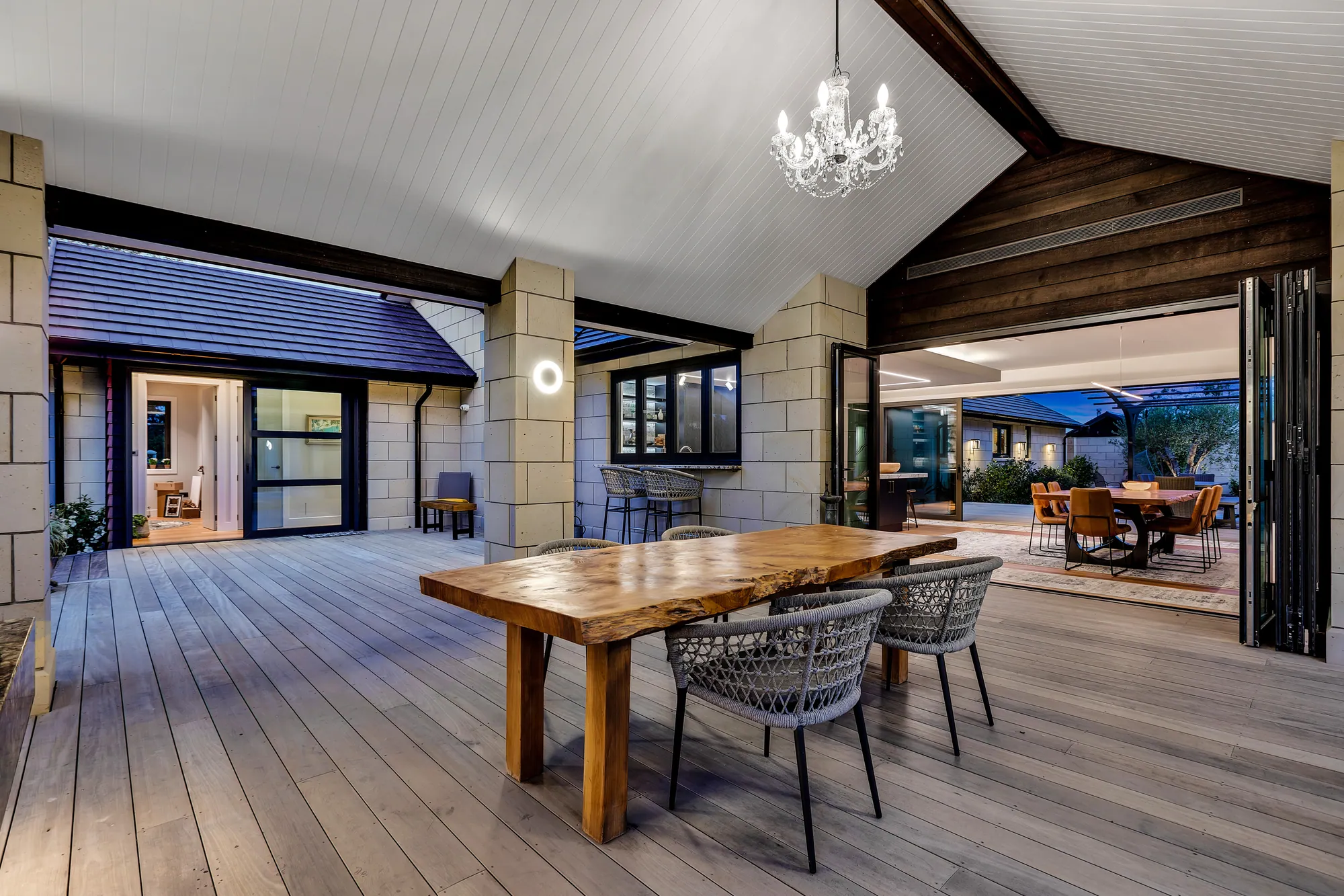 Covered outdoor dining under a gabled roof, opening to the living room