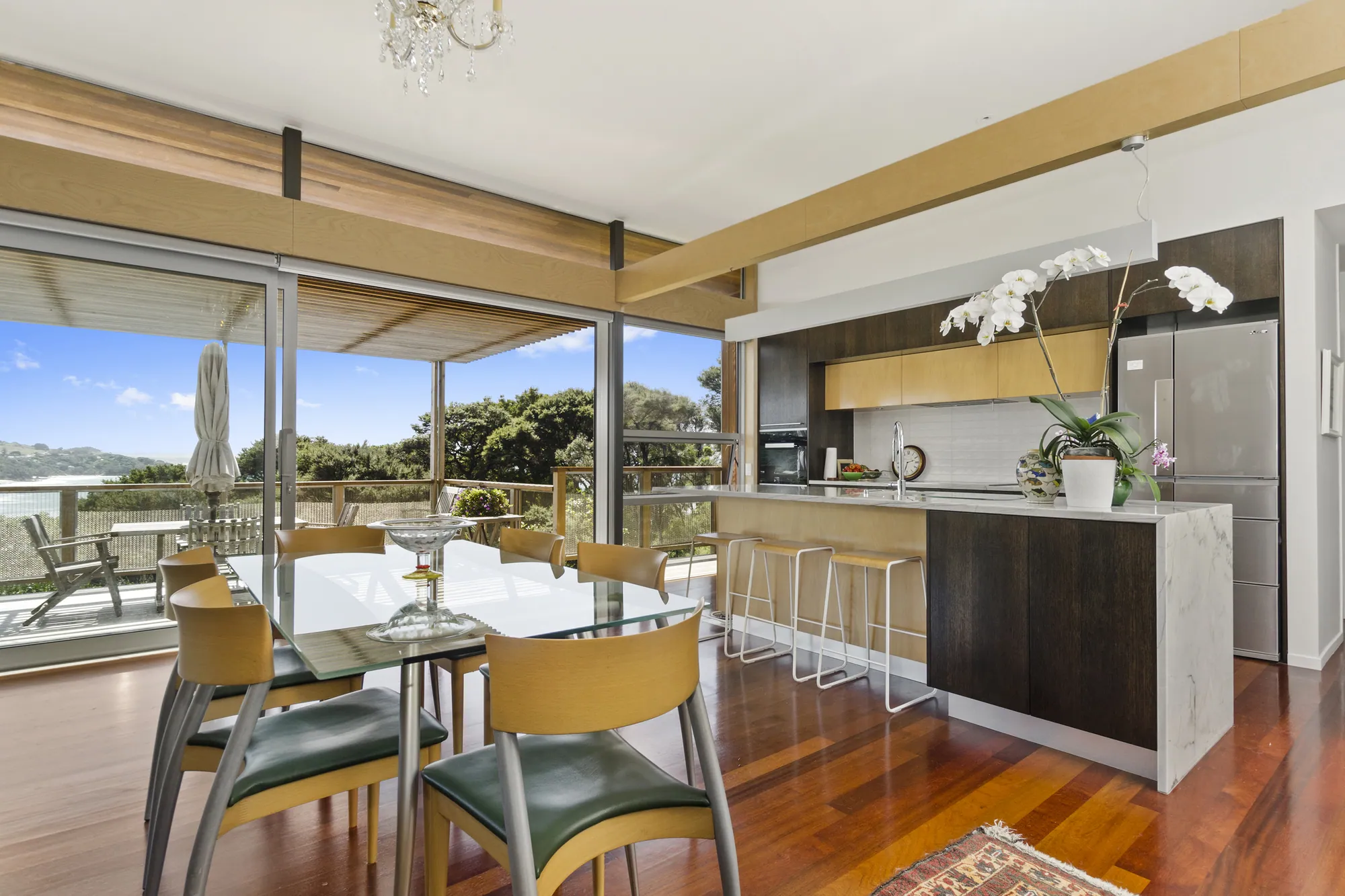 Kitchen and dining with timber floors and windows to the outlook