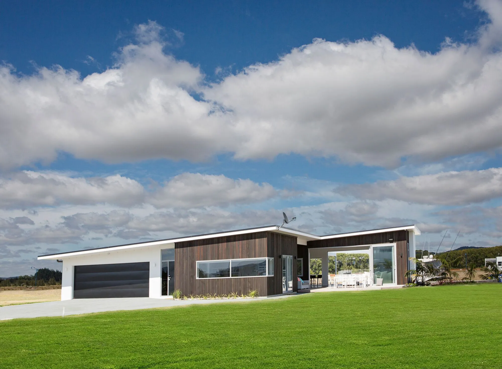 Long, low dark-clad home under an open sky