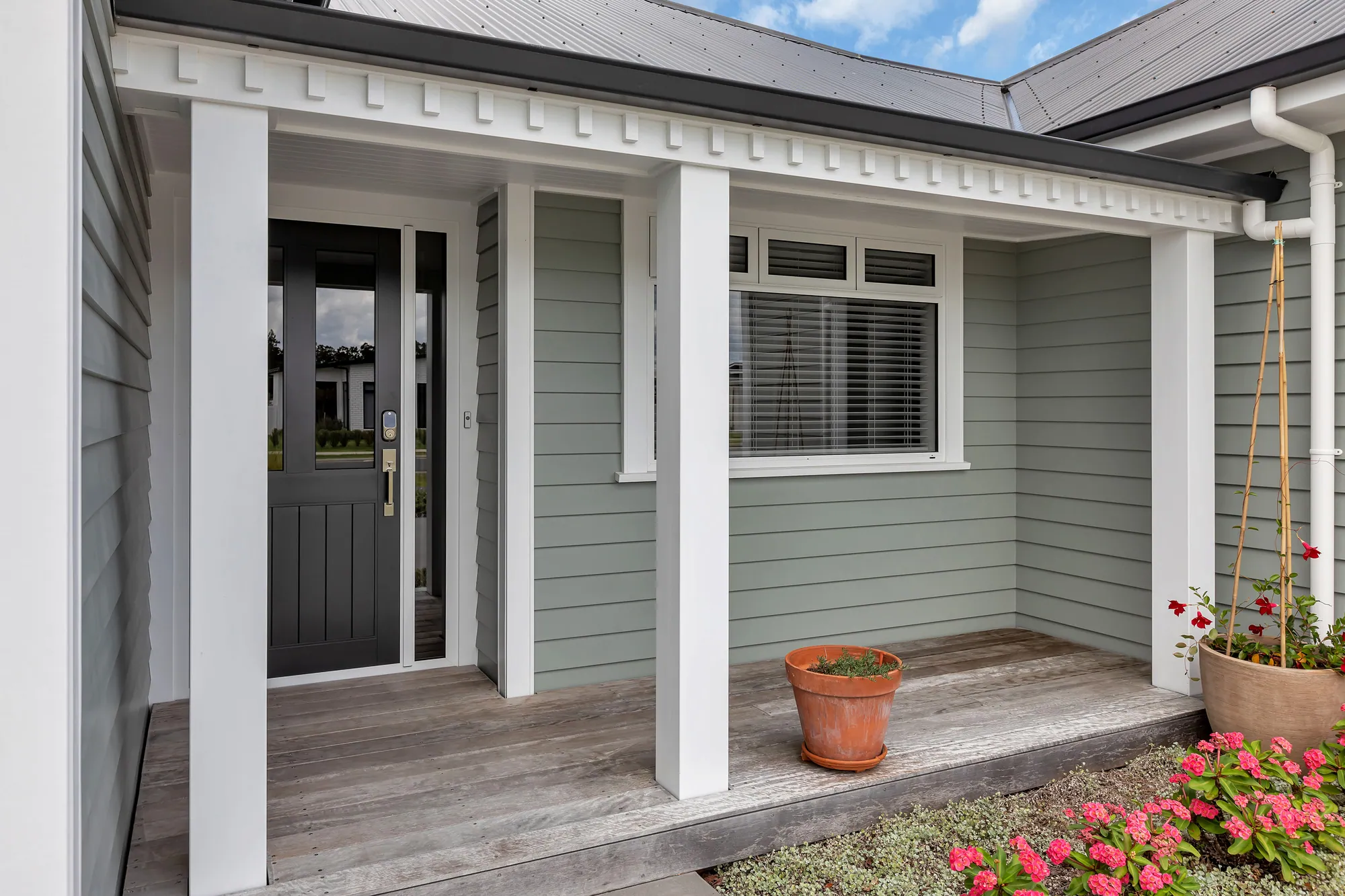 Covered porch with white columns and a solid front door