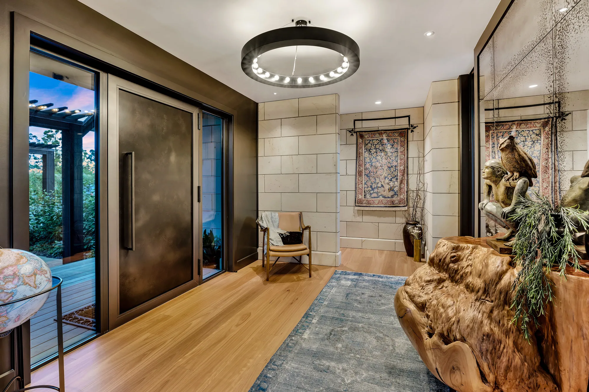 Entry hall with a round pendant light, gilt mirror and timber floor