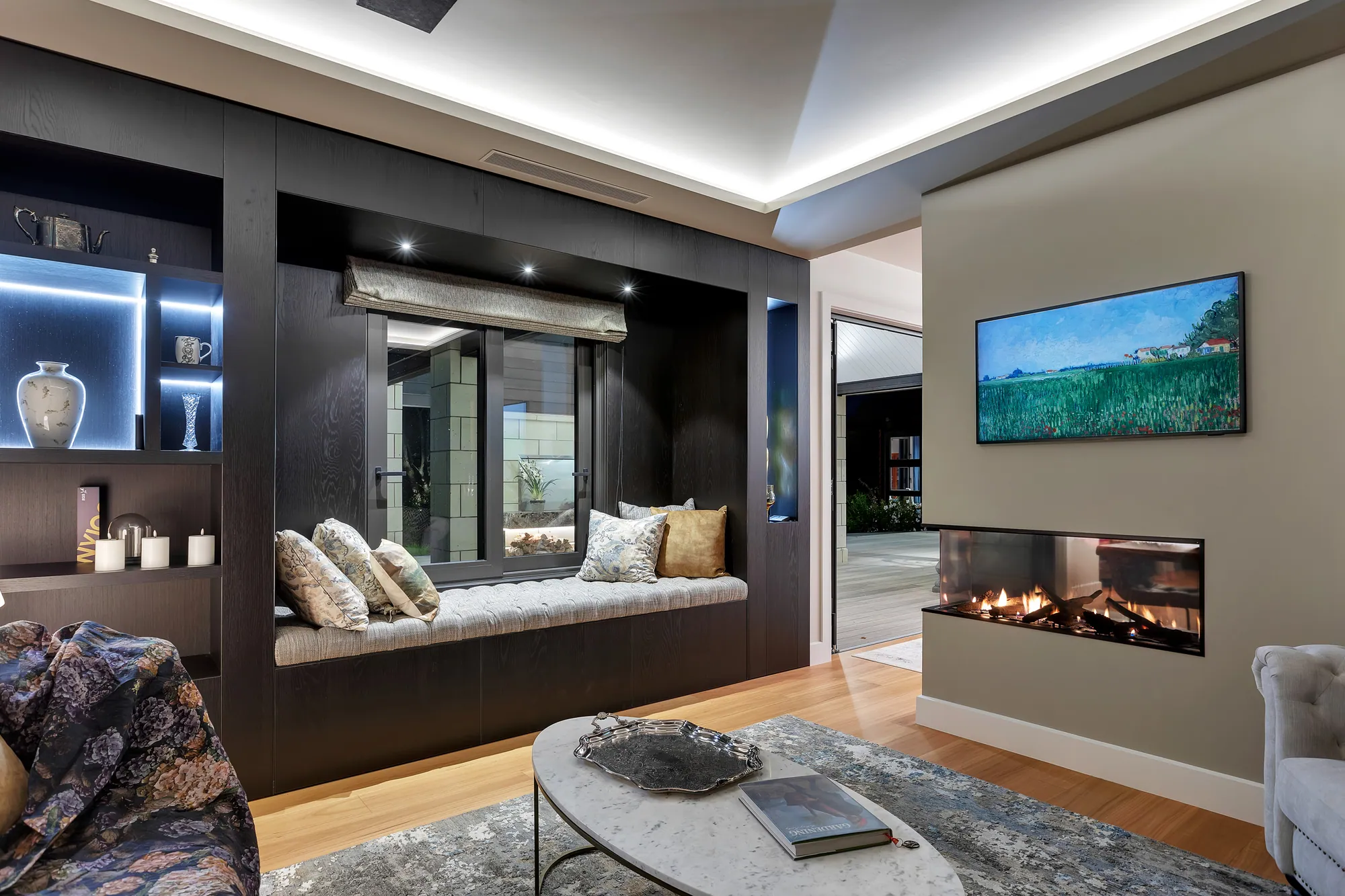 Living room with built-in window seat, shelving and gas fire