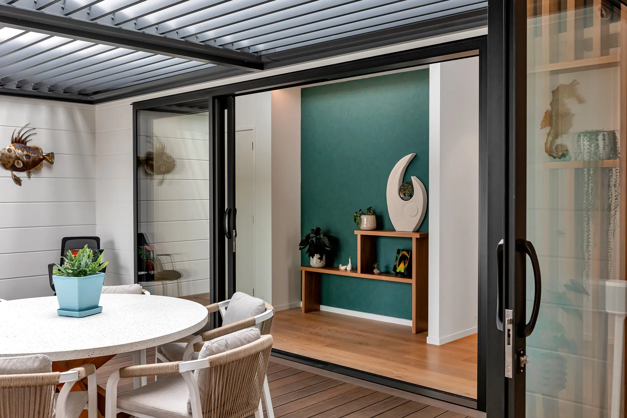 Dining area under a louvred roof opening to the living room