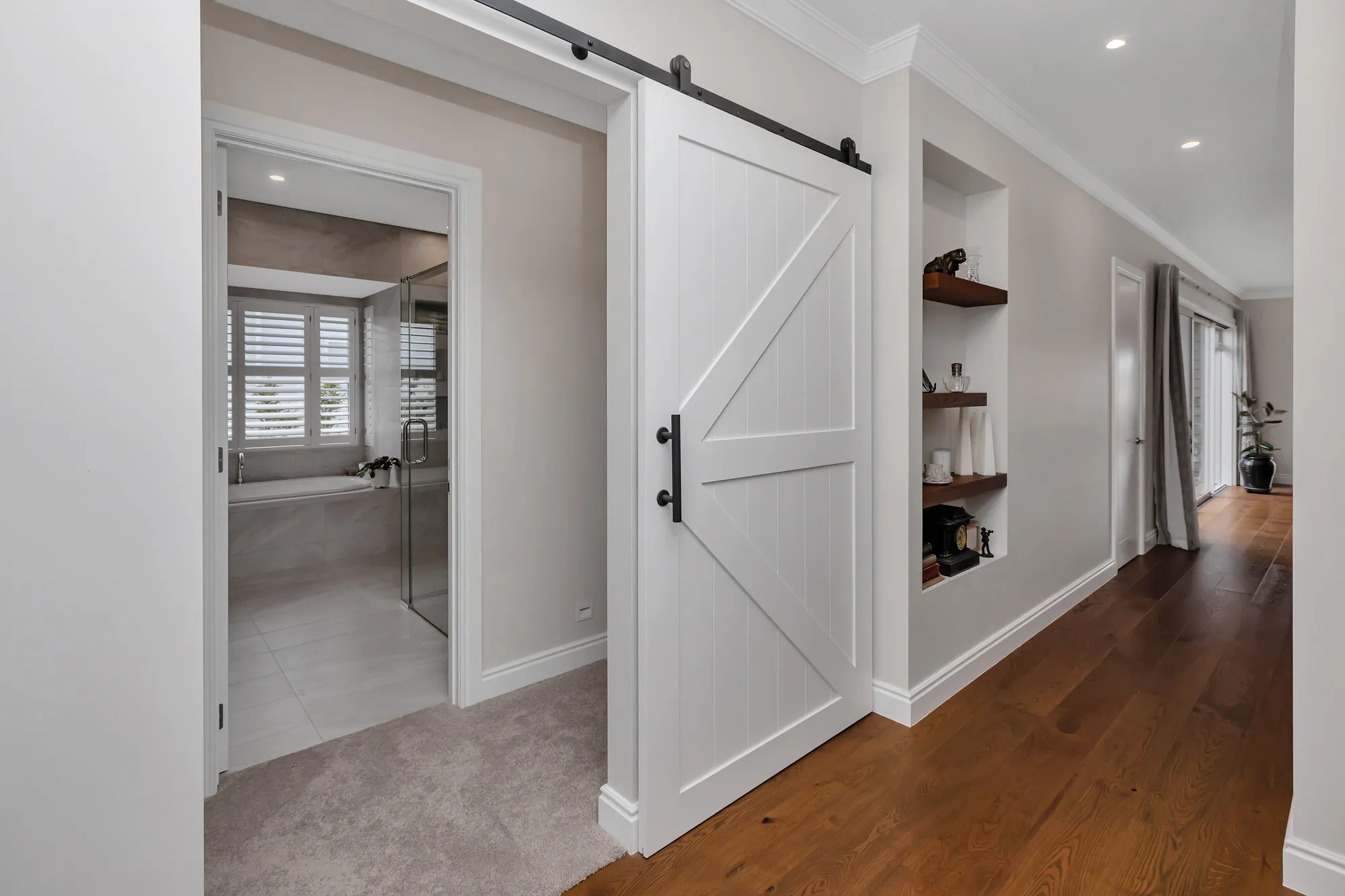 Hallway with a white barn door and built-in shelves