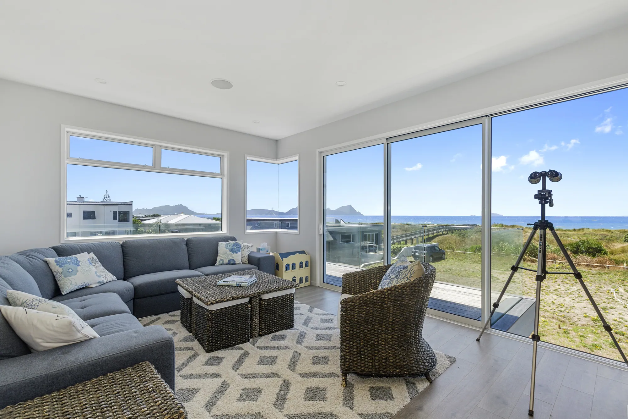 Living room with a telescope and ocean views through sliding doors