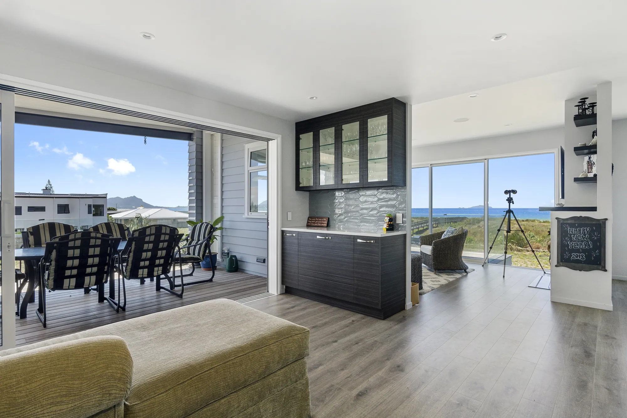 Dining and kitchen joinery opening to the view in a renovated home