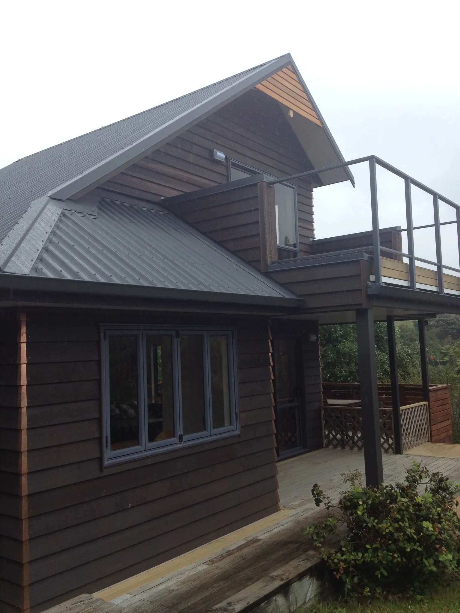 Dark stained weatherboard reclad with a balcony