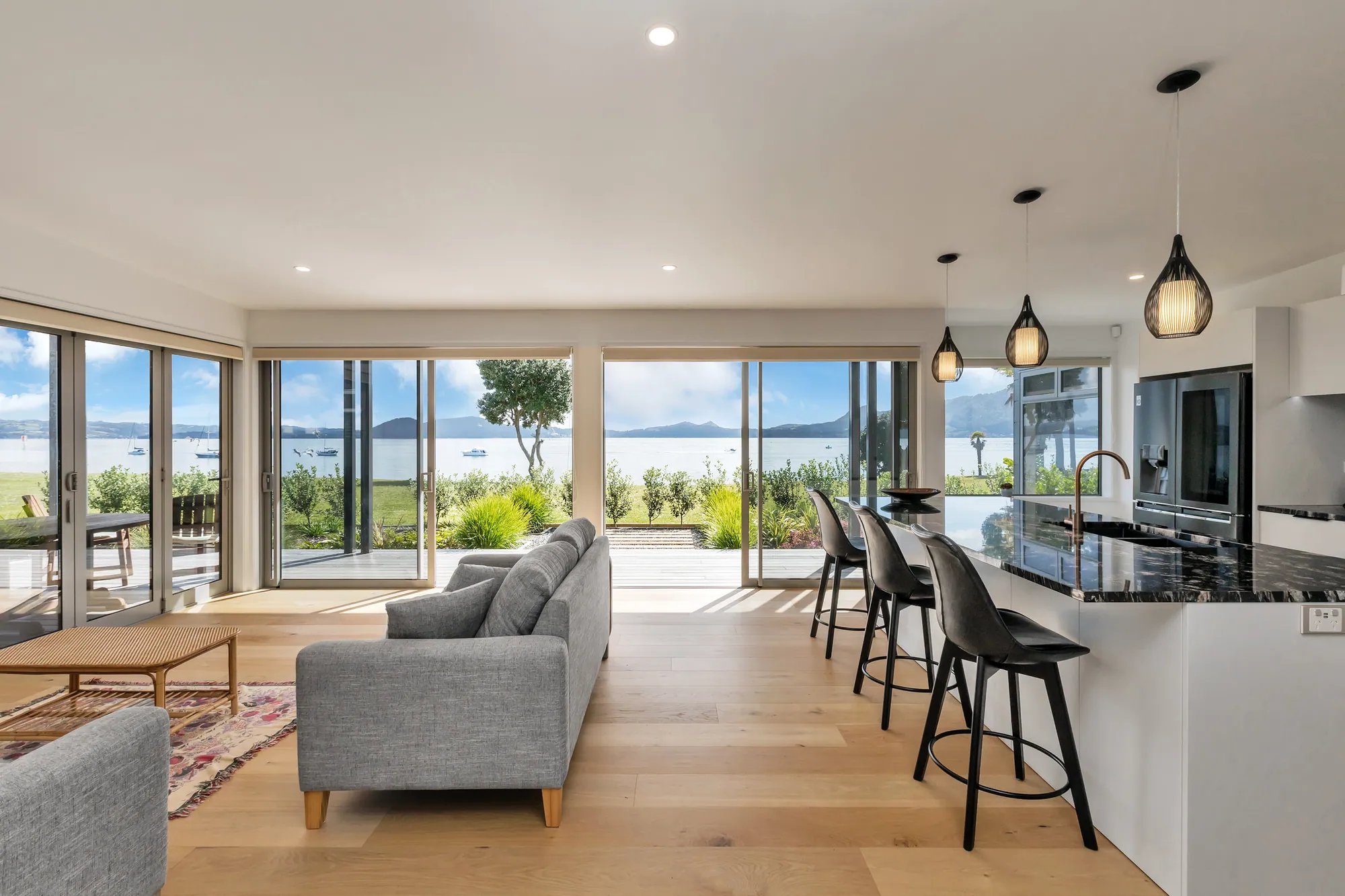 Open-plan living and kitchen with full-height glazing to the harbour