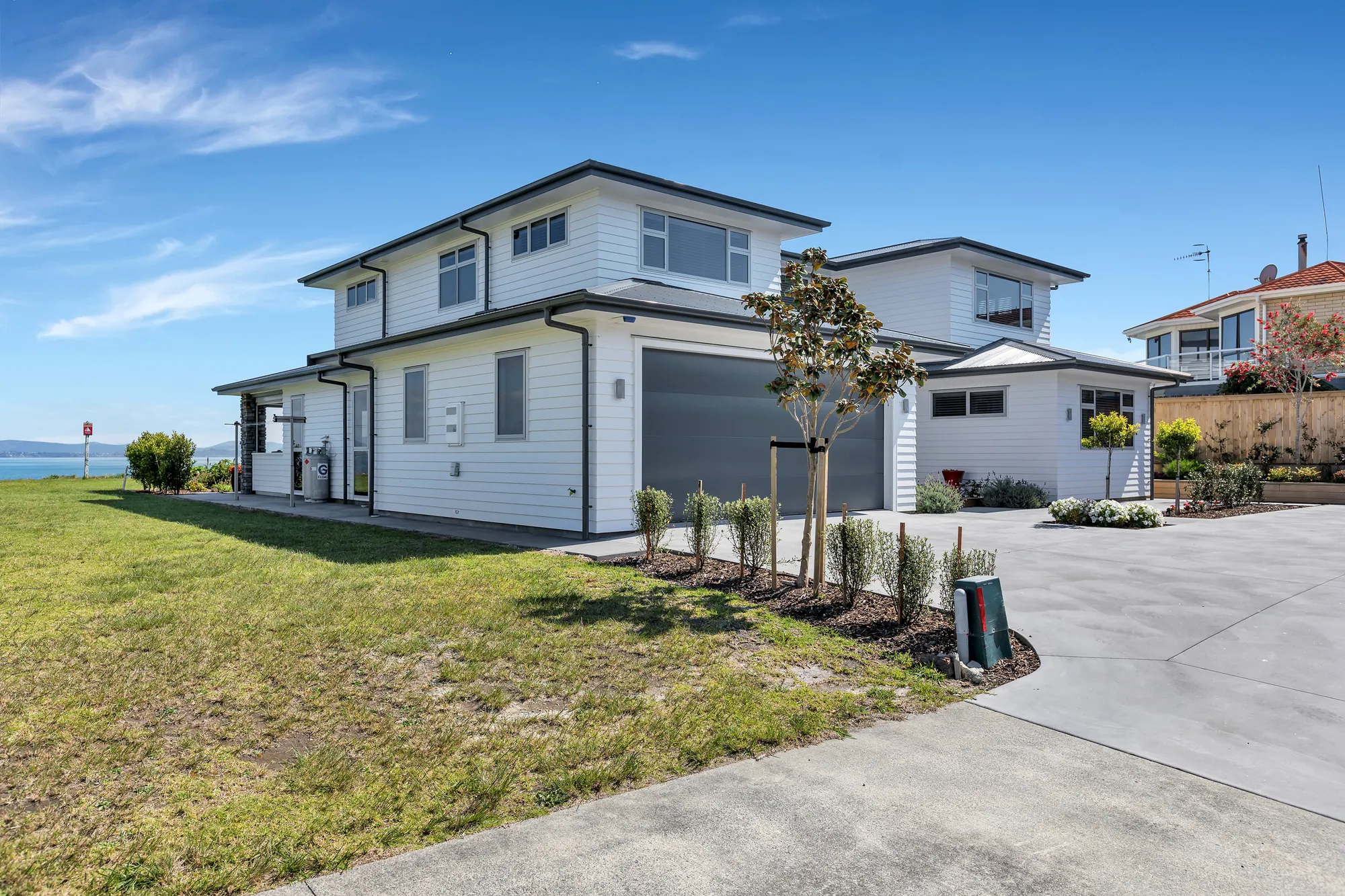 Two-storey weatherboard home on a corner site above the water