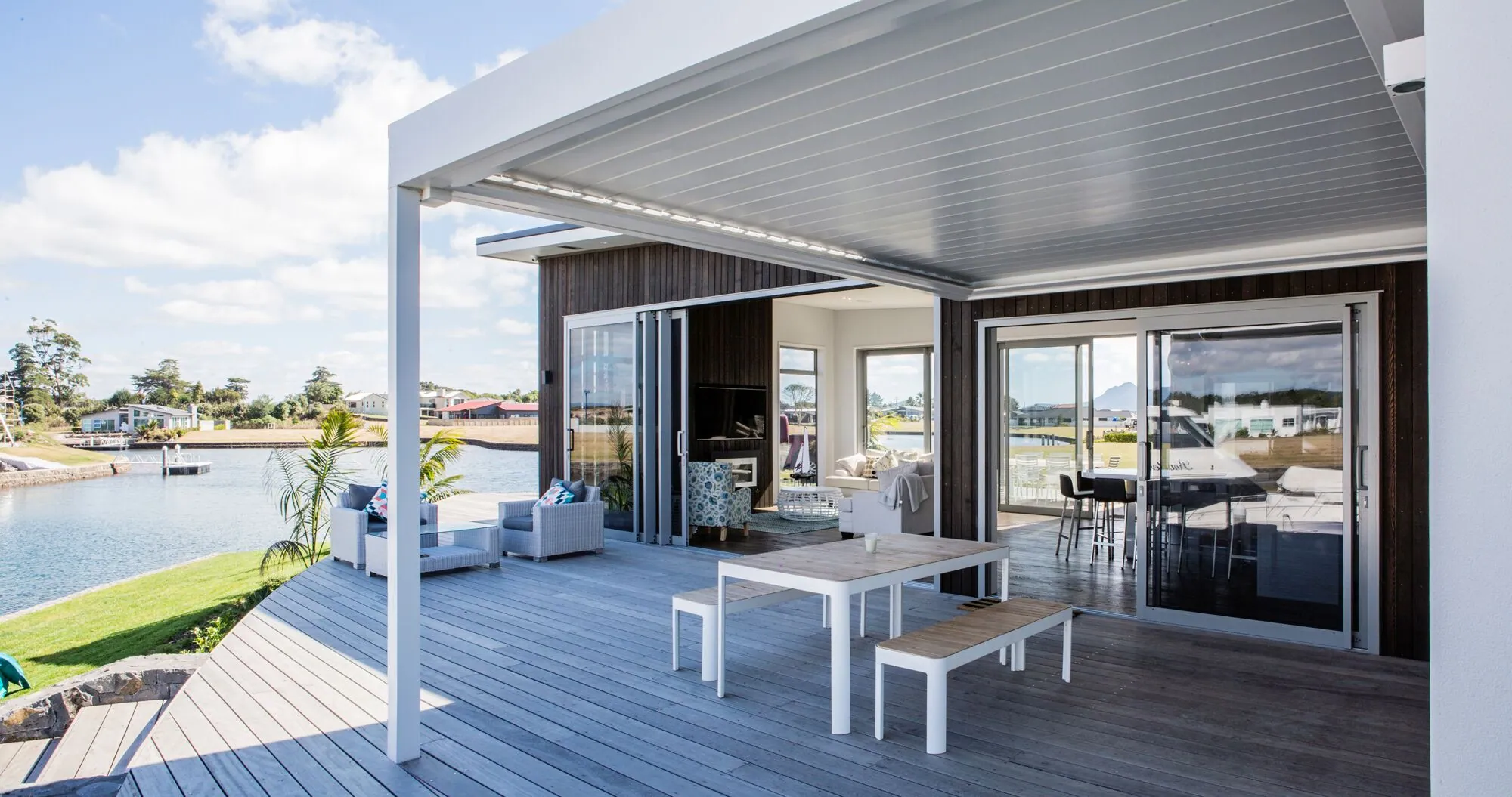 Deck and louvred pergola on the water side of a canal home