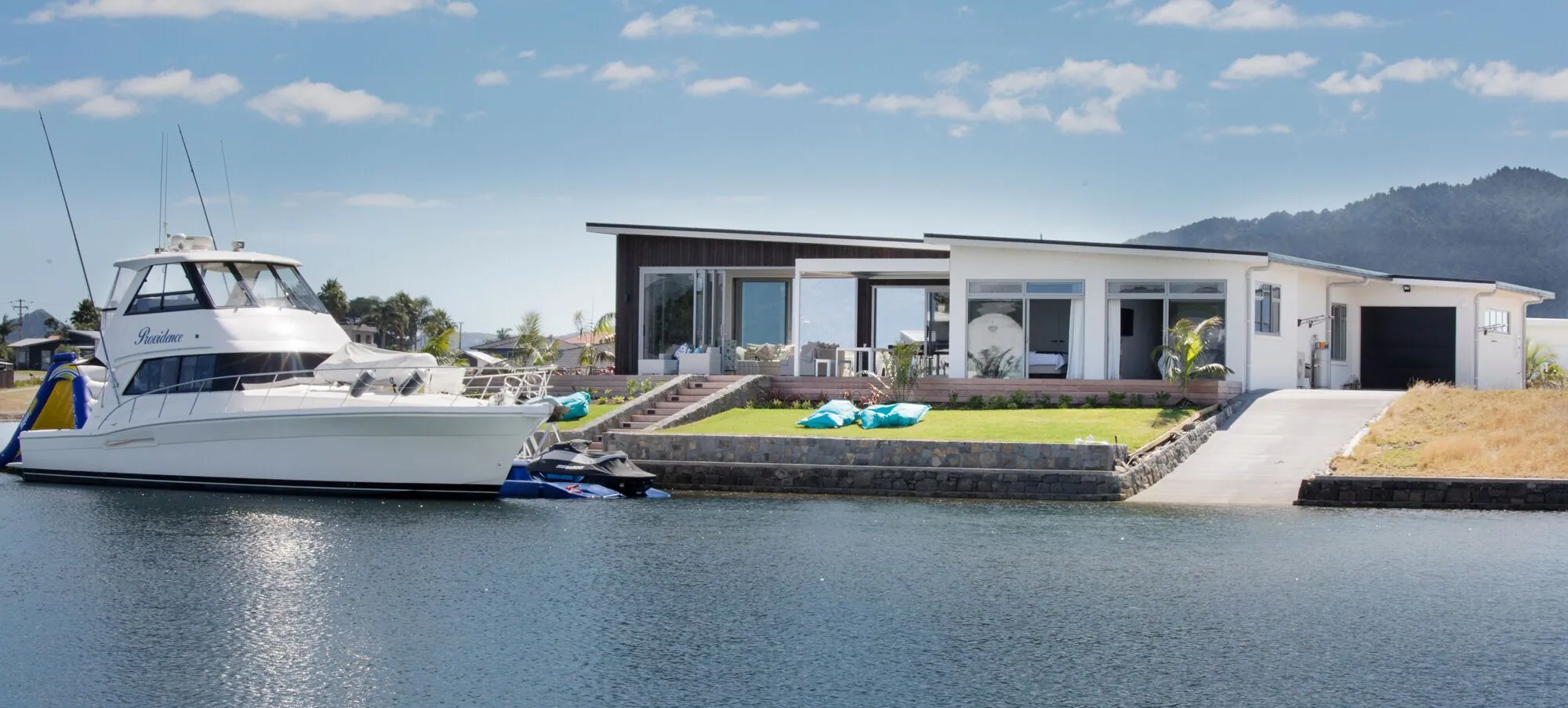 Sport-fishing boat at the berth of a dark-clad canal home