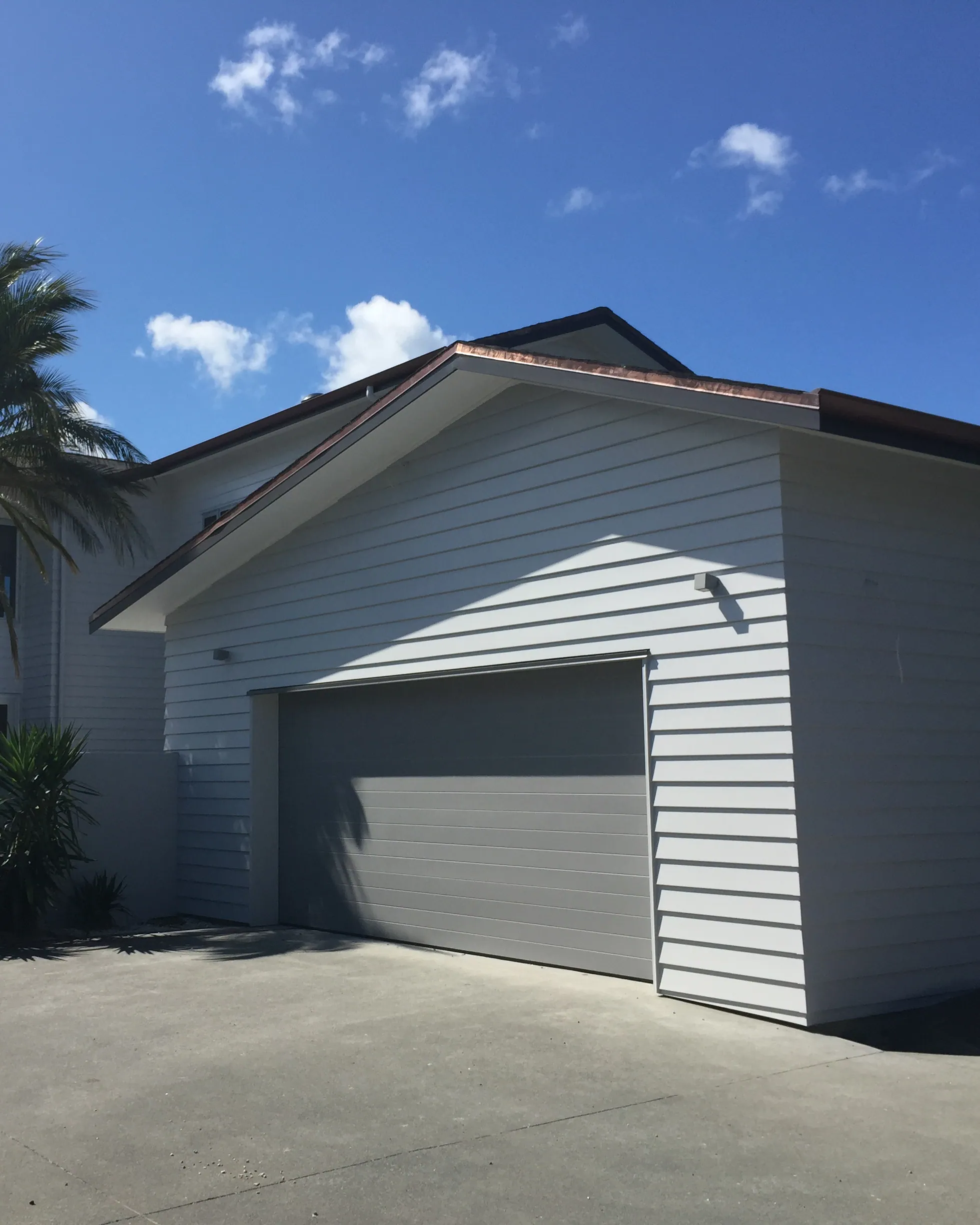 Street elevation of a completed reclad, new weatherboard and garage